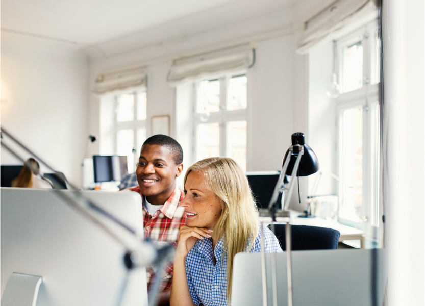 due studenti della Talent Growth Academy in aula osservano con interesse il monitor di un computer mentre sorridono 